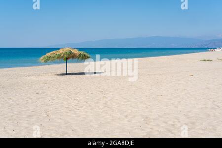 Plage umbrela sur une plage de sable, mer méditerranée, Calabre Italie. Banque D'Images