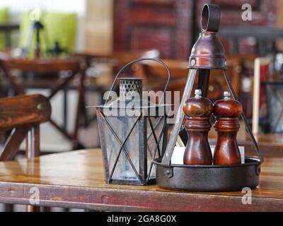 salières et poivrières en bois sur une ancienne table en bois brun dans un restaurant Banque D'Images