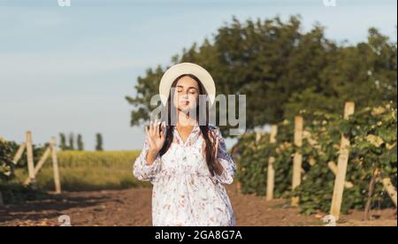 belle fille dans un chapeau parmi le vignoble Banque D'Images