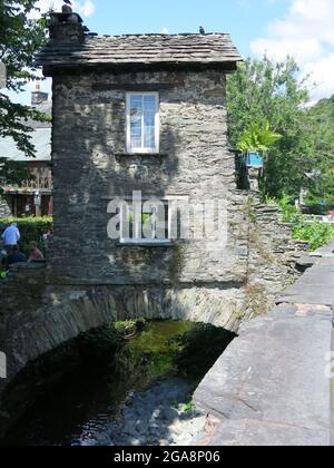 L'un des bâtiments les plus emblématiques du Lake District, le Little Bridge House construit au-dessus de la rivière stock Beck date du XVIIe siècle, Ambleside. Banque D'Images