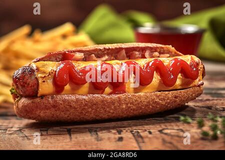 Hot dog dans un rouleau de céréales entières avec saucisse, fromage, sauce tomate Banque D'Images
