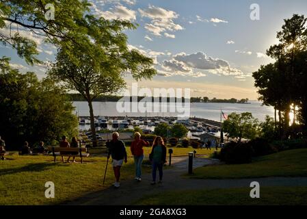 Les gens se détendent sur des bancs dans le parc, regardant un magnifique coucher de soleil, surplombant le port avec des bateaux, à Egg Harbor, comté de Door, Wisconsin, États-Unis Banque D'Images