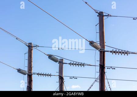 Photographie d'un poste téléphonique en bois et de câbles contre un ciel bleu Banque D'Images