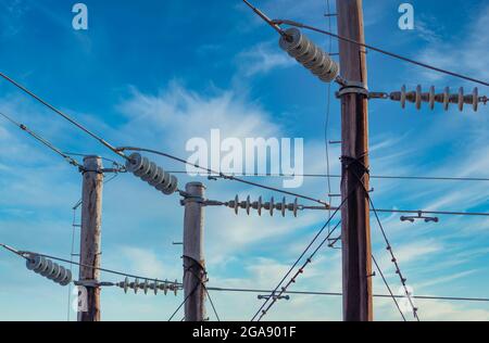 Photographie d'un poste téléphonique en bois et de câbles contre un ciel bleu Banque D'Images