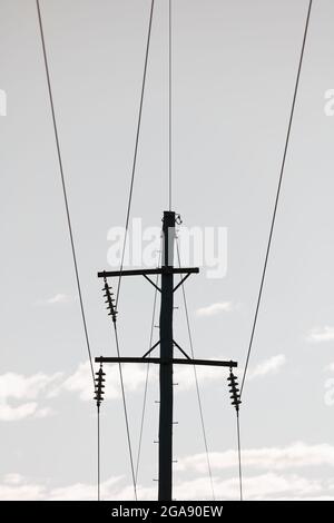 Photographie d'un poste téléphonique en bois et de câbles contre un ciel bleu Banque D'Images