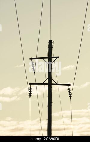 Photographie d'un poste téléphonique en bois et de câbles contre un ciel bleu Banque D'Images