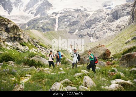 Les femmes avec des sacs à dos et des bâtons scandinaves grimpent dans les montagnes du Caucase Banque D'Images