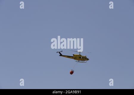 Un hélicoptère de secours en cas d'incendie qui recherche et prend de l'eau pour éteindre un incendie dans les montagnes d'Almanzora, Almeria, Espagne Banque D'Images