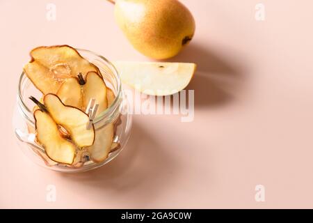 Copeaux de poire dans un pot en verre pour un stockage sur fond beige avec espace de copie. Légumes ou enfants dessert encas sans sucre. Gros plan. Banque D'Images