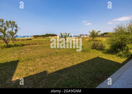 Vue sur la mer depuis la chambre d'hôtel. Pelouse brûlée sur fond bleu ciel. Grèce. Banque D'Images