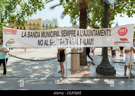 Valence, Espagne. 29 juillet 2021. Musiciens tenant une bannière qui dit "le groupe municipal toujours dans la mairie! Non à leur déménagement aux Palaos!" Au cours de la manifestation, des musiciens de la bande musicale de Valence se sont réunis au Conseil municipal de Valence demandant de ne pas être transférés au Palau de la Musica après les nouvelles conditions de travail. Crédit : SOPA Images Limited/Alamy Live News Banque D'Images