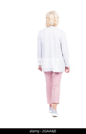 Photo verticale pleine longueur d'une femme caucasienne âgée portant une tenue de marche élégante, fond blanc Banque D'Images