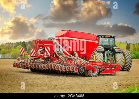 Machine d'ensemencement et de plantation Horsch Pronto 6 DC et tracteur John Deere dans un champ sous un beau ciel. Vue arrière. Salo, Finlande. 16 mai 2021. Banque D'Images