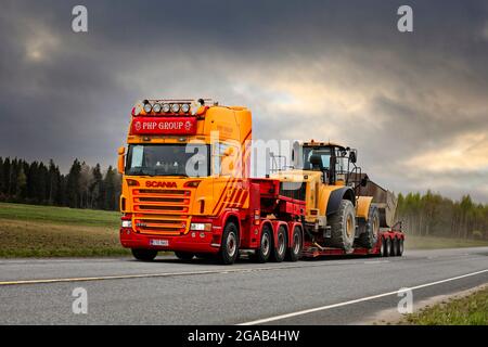 Le camion Scania G580 personnalisé du groupe PHP devant une remorque à col de cygne transporte la chargeuse sur pneus Cat sur la Highway 10. Tammela, Finlande. 14 mai 2021. Banque D'Images