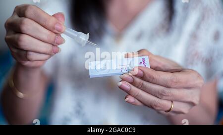 La femme est tenue d'un test d'autocontrôle de l'antigène covid-19 pour un écouvillon nasal avec un résultat négatif. Dispositif médical pour le test du virus corona Banque D'Images