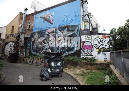 Graffitis à l'extérieur d'un bâtiment et une poubelle à Shoreditch, Londres Banque D'Images