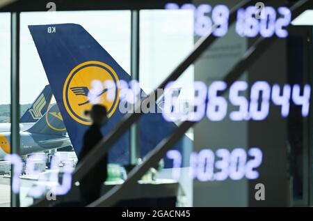 30 juillet 2021, Hessen, Francfort-sur-le-main : les queues des avions de passagers stationnées sur le tablier de l'aéroport de Francfort se reflètent dans un mur de nombres dans le nouveau centre d'accueil. La nouvelle attraction ouvre à temps pour la période des fêtes. Sur 1,200 mètres carrés d'espace d'exposition, près de 30 expositions présentent des aperçus passionnants dans les coulisses de l'aéroport et du vol. Photo: Arne Dedert/dpa Banque D'Images