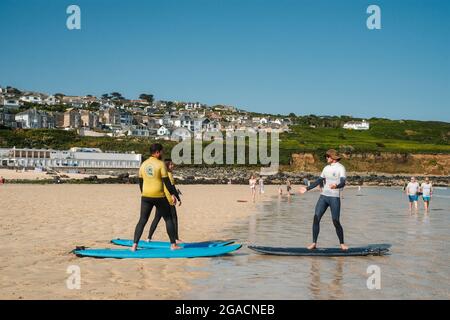 Cours de surf sur la plage de Porthmeor, St Ives, Cornwall, Royaume-Uni. Banque D'Images