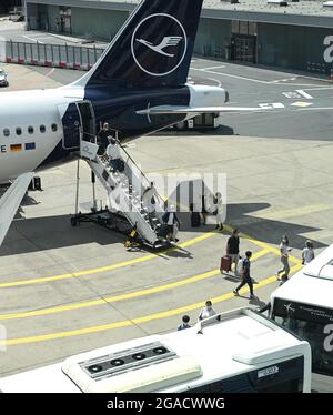 30 juillet 2021, Hessen, Francfort-sur-le-main : les voyageurs aériens quittent un Airbus A320neo de Lufthansa sur le tablier de l'aéroport de Francfort. Pour ceux qui reviennent de leurs vacances d'été, les nouvelles obligations de test pour se protéger contre une propagation de Corona doivent prendre effet à partir de ce dimanche. Photo: Arne Dedert/dpa Banque D'Images