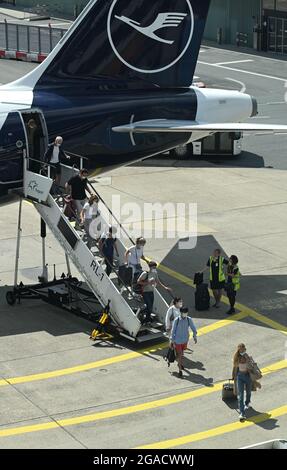 30 juillet 2021, Hessen, Francfort-sur-le-main : les voyageurs aériens quittent un Airbus A320neo de Lufthansa sur le tablier de l'aéroport de Francfort. Pour ceux qui reviennent de leurs vacances d'été, les nouvelles obligations de test pour se protéger contre une propagation de Corona doivent prendre effet à partir de ce dimanche. Photo: Arne Dedert/dpa Banque D'Images