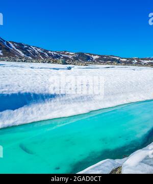 Lac turquoise gelé Vavatn panorama en été paysage et montagnes avec neige à Hemsedal Norvège. Banque D'Images