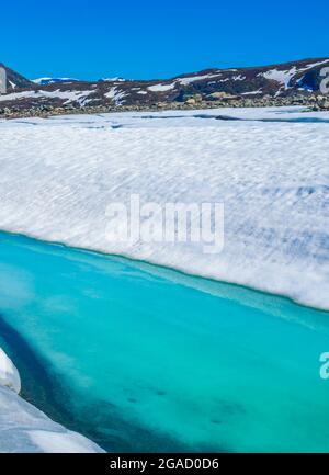 Lac turquoise gelé Vavatn panorama en été paysage et montagnes avec neige à Hemsedal Norvège. Banque D'Images