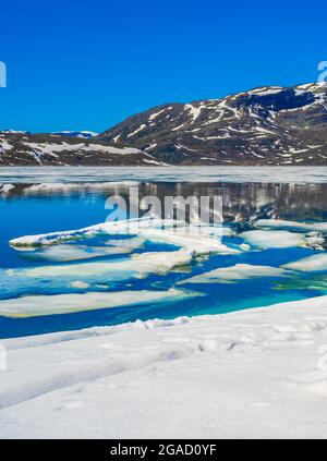 Lac turquoise gelé Vavatn panorama en été paysage et montagnes avec neige à Hemsedal Norvège. Banque D'Images