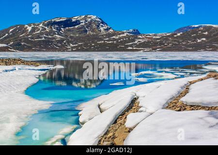 Lac turquoise gelé Vavatn panorama en été paysage et montagnes avec neige à Hemsedal Norvège. Banque D'Images