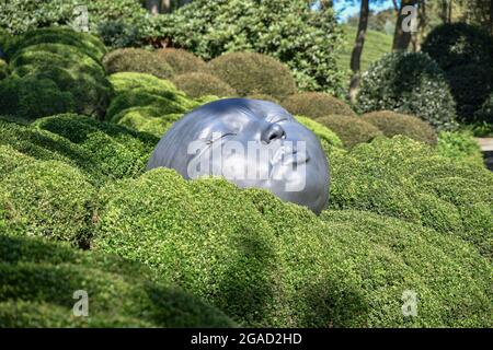 ETRETAT, FRANCE - 02 SEPTEMBRE 2018 : têtes géantes en caoutchouc dormant sur des oreillers verts. Jardin de buis dans le célèbre jardin d'Etretat, en Normandie Banque D'Images