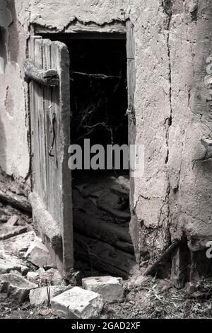 Porte en bois légèrement ouverte et toile d'araignée à l'ancienne sur un fond sombre. Marquage du fond Banque D'Images