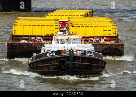 Inland Supply Vessel reprend le remorquage de conteneurs de déchets jaunes sur la Tamise, à Londres, dans le cadre d'un système d'élimination des déchets. ROYAUME-UNI. Banque D'Images