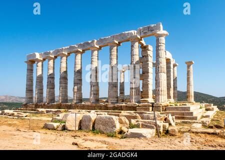 L'ancien temple grec de Poséidon au cap Sounion, les colonnes doriques et les ruines sur la colline avec fond de ciel bleu cristal. Banque D'Images