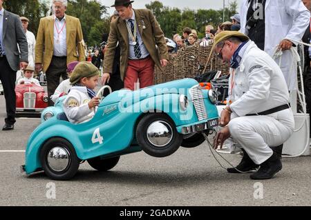 Settrington Cup pilote de course enfant à Austin J40 pédalier au Goodwood Revival, recevant l'aide 'mécanique' de l'un des marshals Banque D'Images