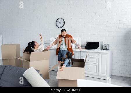 femme et enfant asiatiques dans des boîtes effrayant l'homme dans la nouvelle maison Banque D'Images