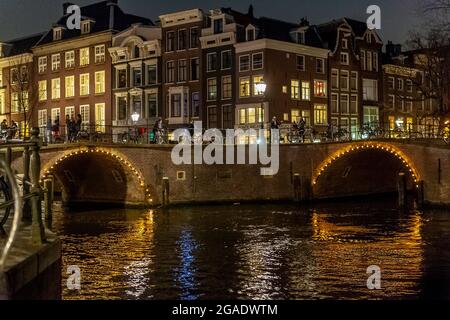 Pont avec arches, illuminé la nuit, canaux Herengracht et Reguliersgracht, Amsterdam Banque D'Images