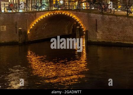 Pont avec arches, illuminé la nuit, canaux Herengracht et Reguliersgracht, Amsterdam Banque D'Images