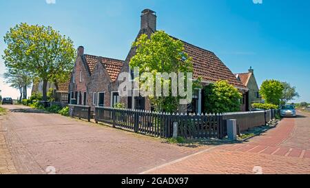 Vieilles maisons traditionnelles néerlandaises le long de la digue à Moddergat Friesland, pays-Bas Banque D'Images