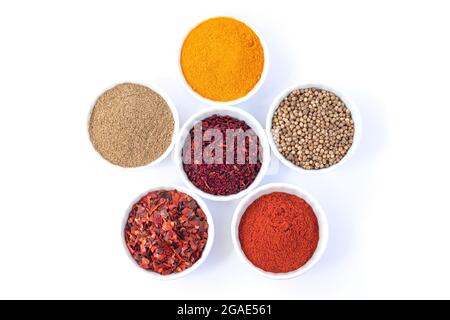 Bols de différentes épices biologiques isolés sur fond blanc vue du dessus Banque D'Images