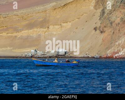 Paracas, Pérou - Mai, 2016: Bateau avec pêcheur solitaire. Îles Ballestas, péninsule de Paracas, province de Pisco, Pérou, Amérique du Sud. Banque D'Images