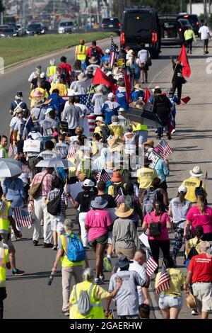 Austin, Texas, États-Unis, 30 juillet 2021 : les groupes de droits de vote défilent le long d'une route de desserte autoroutière vers le capitole du Texas depuis le nord d'Austin le troisième jour d'un voyage de 30 miles protestant contre les efforts des Républicains pour supprimer les votes dans tout le pays et au Texas. Des changements de marcheurs se font échanger dans un effort pour lutter contre la chaleur oppressive du Texas. Crédit : Bob Daemmrich/Alay Live News Banque D'Images