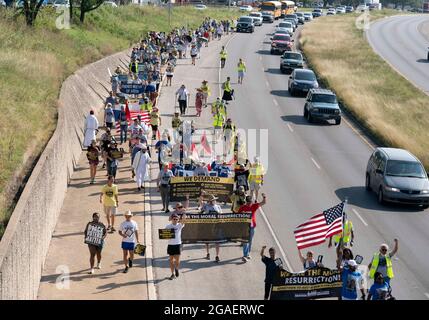 Austin, Texas, États-Unis, 30 juillet 2021 : les groupes de droits de vote défilent le long d'une route de desserte autoroutière vers le capitole du Texas depuis le nord d'Austin le troisième jour d'un voyage de 30 miles protestant contre les efforts des Républicains pour supprimer les votes dans tout le pays et au Texas. Des changements de marcheurs se font échanger dans un effort pour lutter contre la chaleur oppressive du Texas. Crédit : Bob Daemmrich/Alay Live News Banque D'Images
