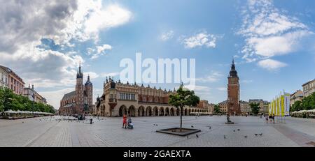 Une photo panoramique de la place principale de Cracovie (Rynek Główny) avec la salle de tissus, la basilique Sainte-Marie et la tour de l'hôtel de ville. Banque D'Images