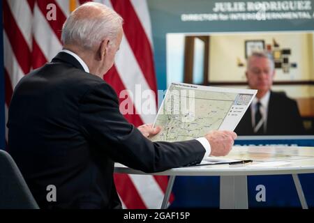 Washington DC, États-Unis. 30 juillet 2021. Le président des États-Unis Joe Biden examine une carte des feux de forêt au Montana lors d'une réunion virtuelle avec les gouverneurs pour discuter des efforts de prévention, de préparation et d'intervention en cas d'incendie de forêt au bureau exécutif Eisenhower près de la Maison Blanche à Washington DC, aux États-Unis, le vendredi 30 juillet 2021. Crédit : Sarah Silbiger/Pool via CNP/dpa/Alay Live News Banque D'Images