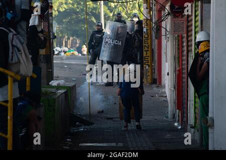 Un manifestant utilisant un bouclier en bois se tient devant la police anti-émeutes de Colombie alors que les manifestations se terminaient par des affrontements de nuit entre la police anti-émeutes de Colombie (ESMAD) et des manifestants alors que la Colombie marquait 3 mois de manifestations anti-gouvernementales contre le président colombien Ivan Duque, et une nouvelle réforme fiscale au milieu des troubles et de la violence qui ont fait au moins 83 morts depuis le début des manifestations. Le 28 juillet 2021 à Medellin - Antioquia, Colombie. Banque D'Images