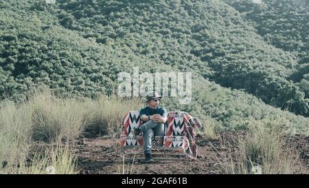Jeune asiatique homme assis chaise bohemian hors camping mode de vie de l'homme voyage dans un camp de week-end Banque D'Images