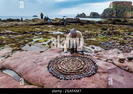 James Brunt, artiste terrestre, crée une sculpture sur roche sur la plage, Dunbar, East Lothian, Écosse, Royaume-Uni Banque D'Images