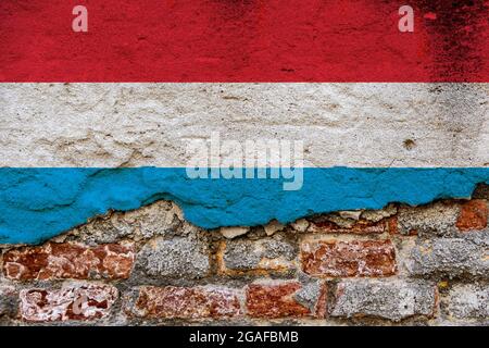 Concept graphique avec un drapeau du Luxembourg peint sur un mur de briques endommagé. Banque D'Images