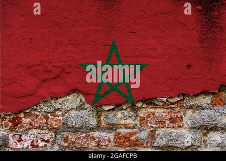 Concept graphique avec un drapeau du Maroc peint sur un mur de briques endommagé. Banque D'Images