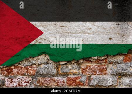 Concept graphique avec un drapeau de Palestine peint sur un mur de briques endommagé. Banque D'Images