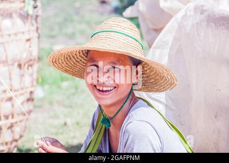 Jolie fille birmane portant un chapeau de paille avec taches de noix de bétel sur les dents, Mine Thauk, Inle Lake, Myanmar Banque D'Images